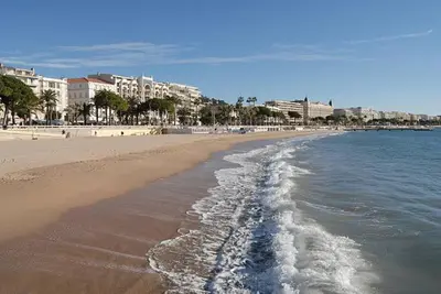 a sandy beach with buildings and the ocean at Butterfly-Palais des Festival-center-quiet-AC-Wi Fi parking in Cannes
