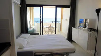 a bedroom with a bed with a view of a balcony at Appartement 753, 4 personnes, vue mer By Palmazur in Cannes