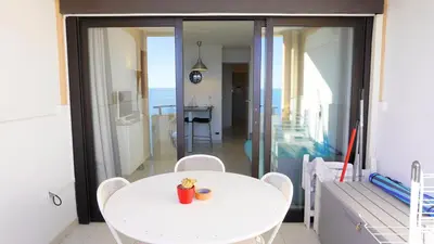 a white table and chairs in a room with a balcony at Appartement 753, 4 personnes, vue mer By Palmazur in Cannes