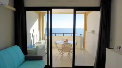 a living room with a table and a view of the ocean at Appartement 753, 4 personnes, vue mer By Palmazur in Cannes