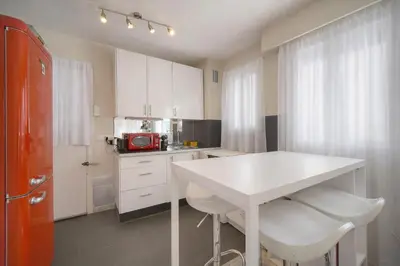 a kitchen with a white counter and a red refrigerator at FRGK FR - Surcouf 'PALM BEACH ' in Cannes