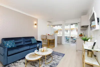 a living room with a blue couch and a table at Perle Dorée YourHostHelper in Cannes