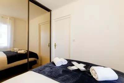 a bedroom with two beds with towels and a mirror at Perle Dorée YourHostHelper in Cannes