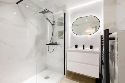 a white bathroom with a shower and a sink at Perle Dorée YourHostHelper in Cannes