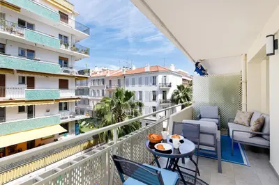 a balcony with a table and chairs on a balcony at Perle Dorée YourHostHelper in Cannes