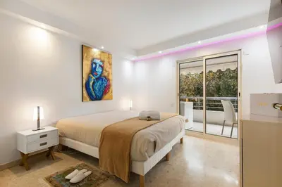 a white bedroom with a bed and a window at croisette3bedroomterrasse in Cannes