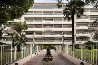 a large white building with trees in front of it at croisette3bedroomterrasse in Cannes