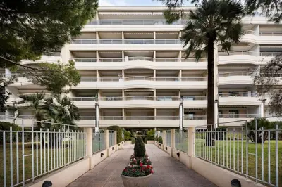 a large white building with flowers in front of it at croisette3bedroomterrasse in Cannes
