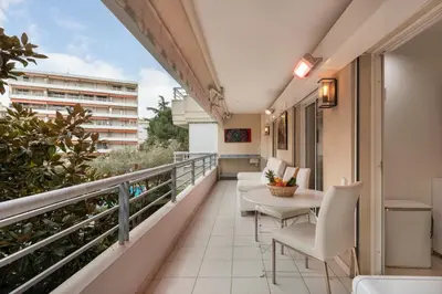 a balcony with chairs and a table on a building at croisette3bedroomterrasse in Cannes