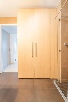 a large wooden cabinet in a room with a bathroom at Joli studio centre Cannes in Cannes