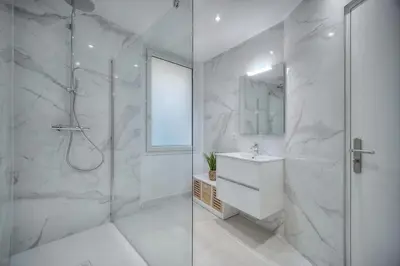 a white bathroom with a shower and a sink at Duplex 5 chambres PATIO, Clémenceau-CENTRE CANNES A5B003 in Cannes