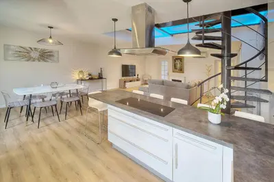 a kitchen and living room with a dining table and a staircase at Duplex 5 chambres PATIO, Clémenceau-CENTRE CANNES A5B003 in Cannes