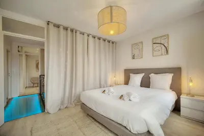 a bedroom with a large white bed with two towels on it at Duplex 5 chambres PATIO, Clémenceau-CENTRE CANNES A5B003 in Cannes