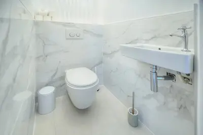 a white bathroom with a toilet and a sink at Duplex 5 chambres PATIO, Clémenceau-CENTRE CANNES A5B003 in Cannes