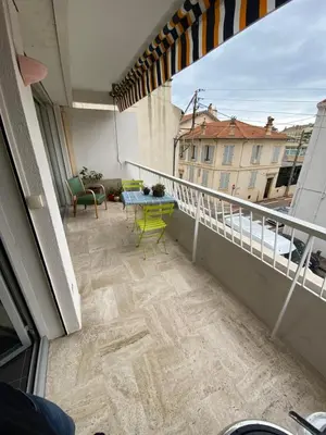 a balcony with a table and chairs on a building at Grand appartement de style avec parking - Cannes in Cannes