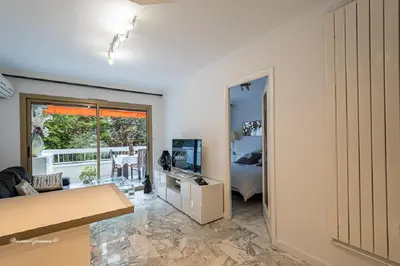 a living room with a couch and a television at Ô 27 Fleurie Cannes in Cannes