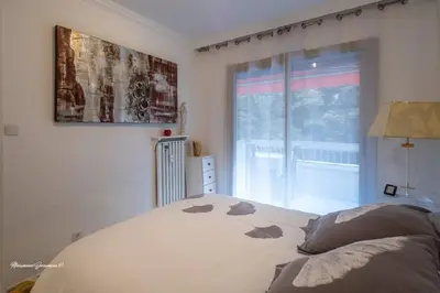a bedroom with a bed and a large window at Ô 27 Fleurie Cannes in Cannes