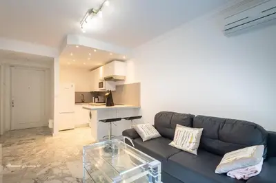 a living room with a couch and a kitchen at Ô 27 Fleurie Cannes in Cannes