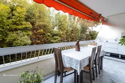 a table and chairs on a balcony with a large window at Ô 27 Fleurie Cannes in Cannes
