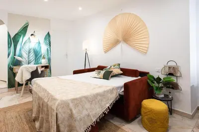 a bedroom with a bed with a table and a fan on the wall at C6 - Studio Rue Félix Faure 2 min Palais Festivals - AC & Balcony in Cannes