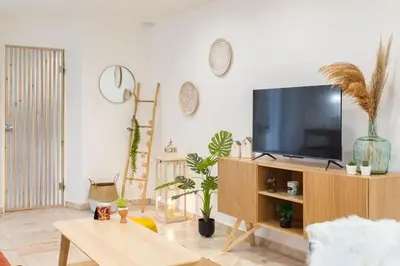 a living room with a tv on a wooden entertainment center at C6 - Studio Rue Félix Faure 2 min Palais Festivals - AC & Balcony in Cannes