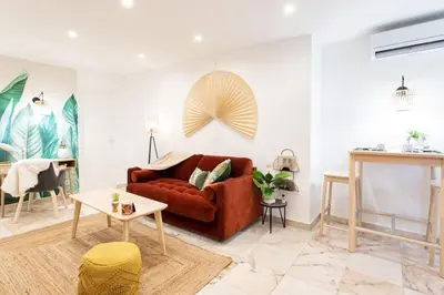 a living room with a red couch and a table at C6 - Studio Rue Félix Faure 2 min Palais Festivals - AC & Balcony in Cannes