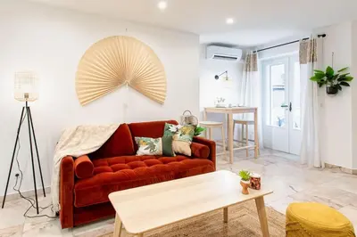 a living room with a red couch and a table at C6 - Studio Rue Félix Faure 2 min Palais Festivals - AC & Balcony in Cannes