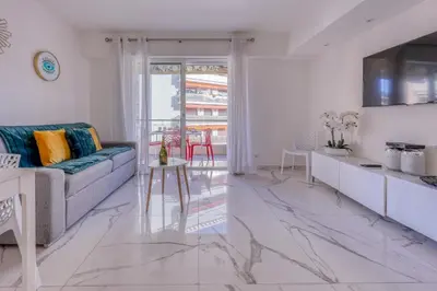 a living room with a couch and a table at Cannes le Versailles Standing Presta in Cannes