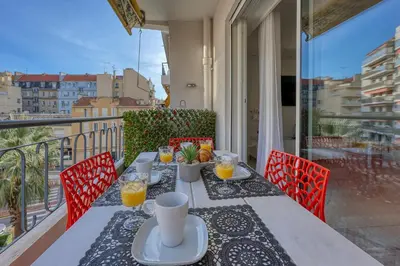a table on a balcony with glasses of orange juice at Cannes le Versailles Standing Presta in Cannes