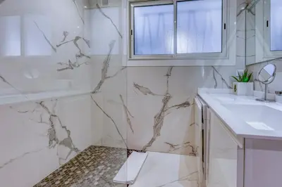 a white bathroom with a sink and a mirror at Cannes le Versailles Standing Presta in Cannes