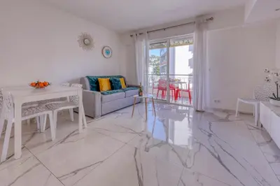 a white living room with a table and a couch at Cannes le Versailles Standing Presta in Cannes
