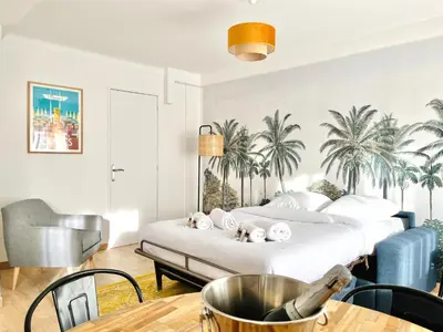 a bedroom with a bed with palm trees on the wall at Le CozyCroisette - Centre Cannes - 6 personnes in Cannes