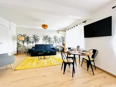 a living room with a table and a blue couch at Le CozyCroisette - Centre Cannes - 6 personnes in Cannes