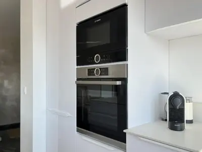 a kitchen with a black oven with a microwave at Le Panoramique - 4 pièces centre Cannes in Cannes