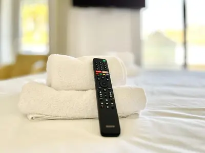 a remote control sitting on top of towels on a bed at Le Panoramique - 4 pièces centre Cannes in Cannes