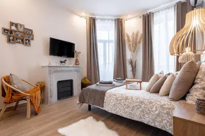 a living room with a bed and a fireplace at L'atelier des Artistes -Écrin de sérénité au coeur de Cannes - Balcon - Clim - Wifi in Cannes