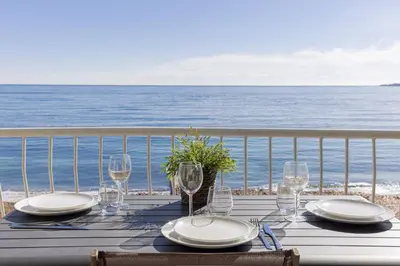 a table with plates and wine glasses on the beach at The Beach Cocoon – Sea View & Calm in Cannes