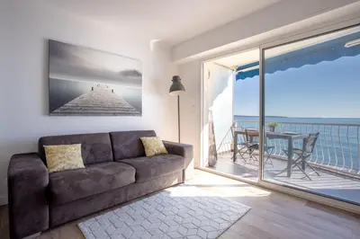 a living room with a couch and a view of the ocean at The Beach Cocoon – Sea View & Calm in Cannes
