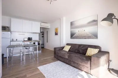 a living room with a couch and a table at The Beach Cocoon – Sea View & Calm in Cannes