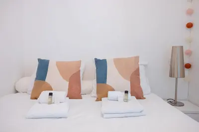 a white bed with pillows and towels on it at The Beach Cocoon – Sea View & Calm in Cannes