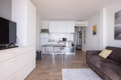a living room with a couch and a table and a kitchen at The Beach Cocoon – Sea View & Calm in Cannes