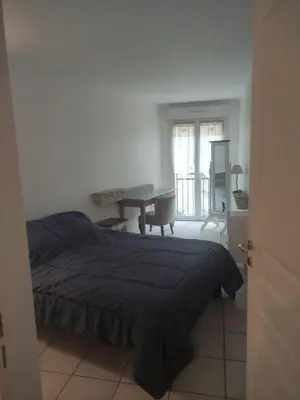 a bedroom with a bed and a desk and a window at LE PALAZZIO - Proximité immédiate Palais des festival ,Vieux Port et plages - Garage in Cannes