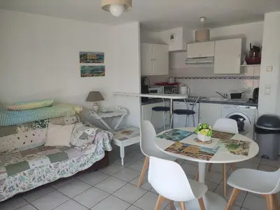 a kitchen and a living room with a table and chairs at LE PALAZZIO - Proximité immédiate Palais des festival ,Vieux Port et plages - Garage in Cannes