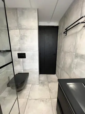 a bathroom with a toilet and a black door at Ciel de Cannes in Cannes