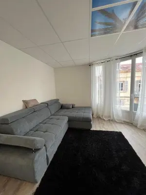 a living room with a gray couch and a large window at Ciel de Cannes in Cannes
