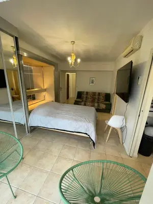 a bedroom with a bed and a table and chairs at Cool Appart sur Croisette Palm Beach in Cannes