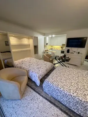 a bedroom with two beds and a chair at Cool Appart sur Croisette Palm Beach in Cannes