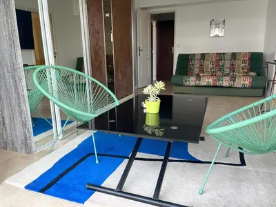 two green chairs and a table in a living room at Cool Appart sur Croisette Palm Beach in Cannes