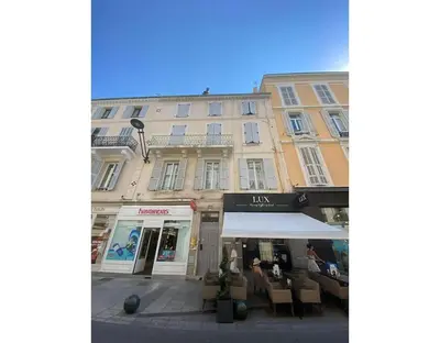 a building with a cafe in front of it at Luxury Apt With Balcony On Famous Rue D'antibes! - Kiss Apartment by Halldis in Cannes