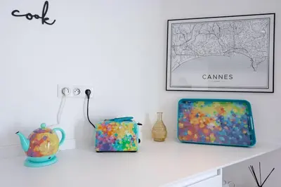 a shelf with a picture and some vases on it at Luxury Apt With Balcony On Famous Rue D'antibes! - Kiss Apartment by Halldis in Cannes